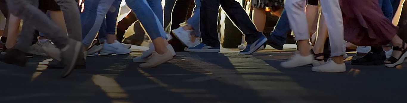 Un paso de peatones muestra a docenas de personas caminando en direcciones opuestas mientras cruzan la calle