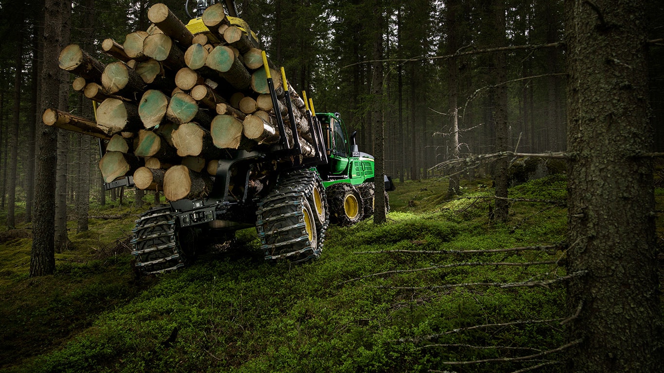 El transportador de troncos 1510G de John Deere transporta troncos en el bosque